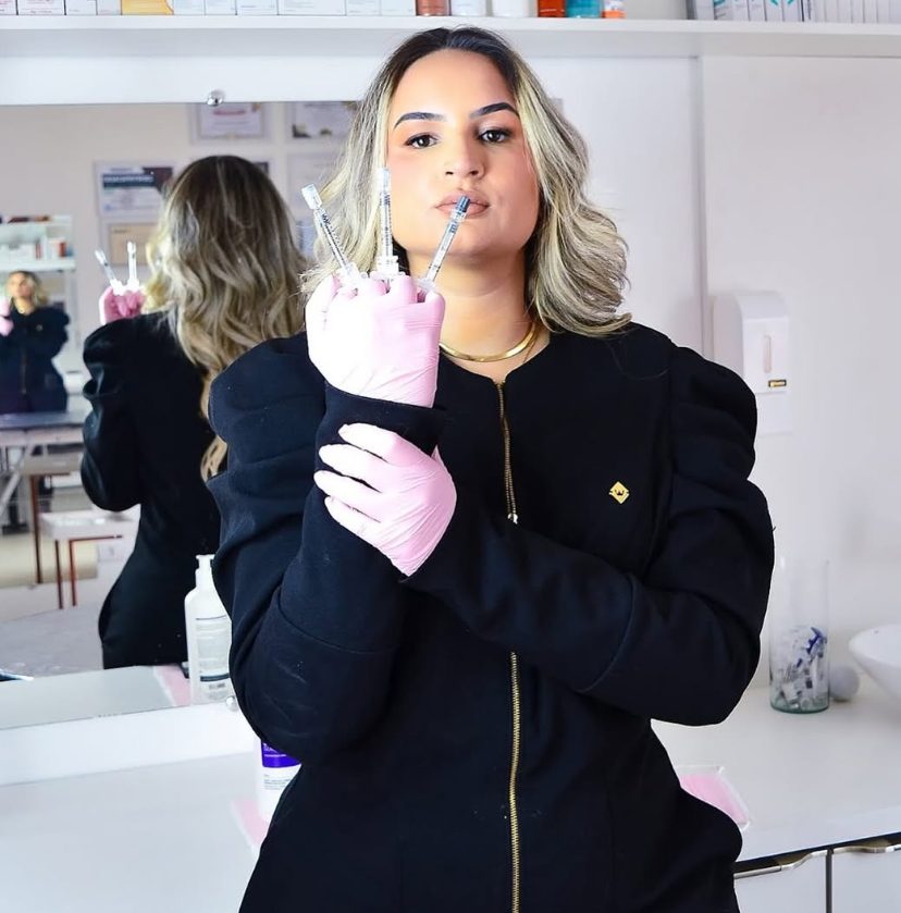Dra. Nidiane Sovinski segurando seringas de preenchimento